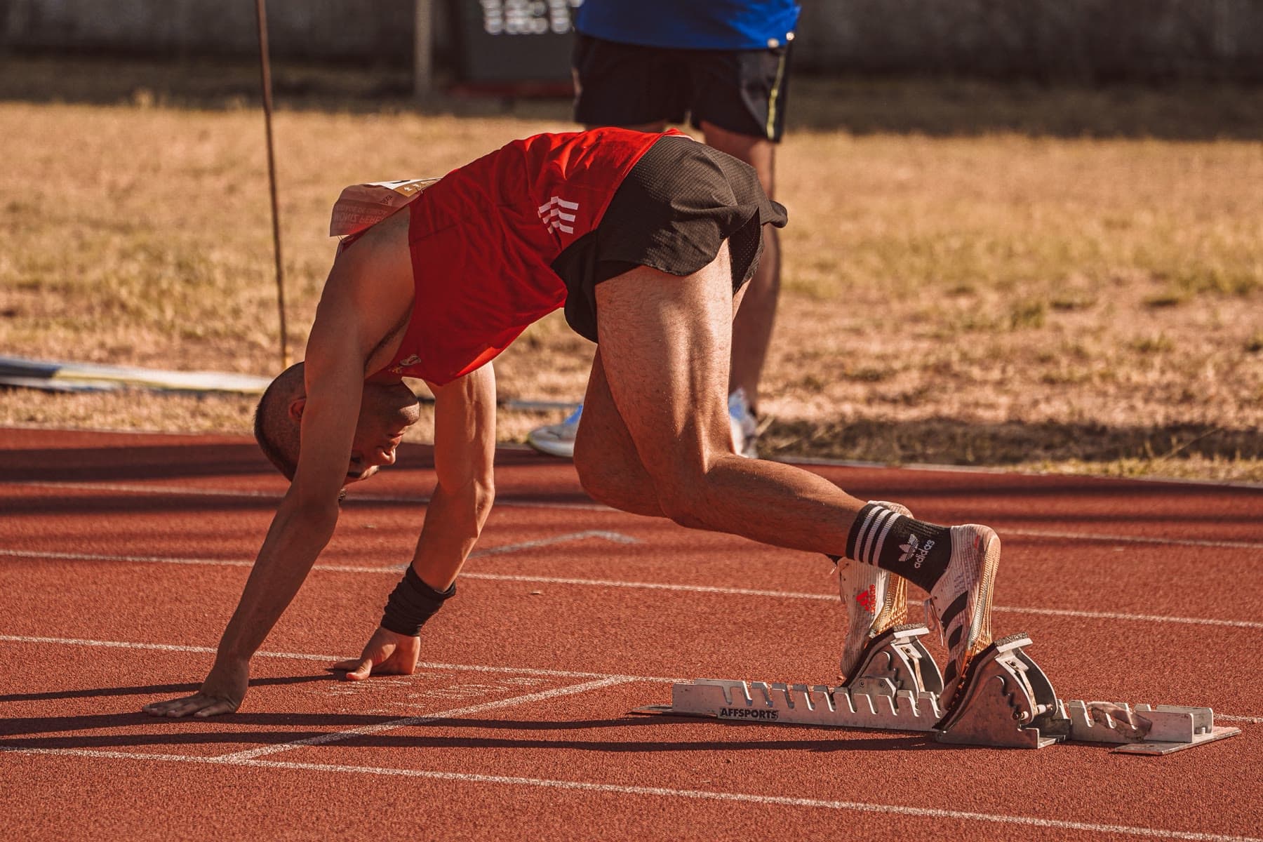 Sprinter exploding out of the starting blocks on a track