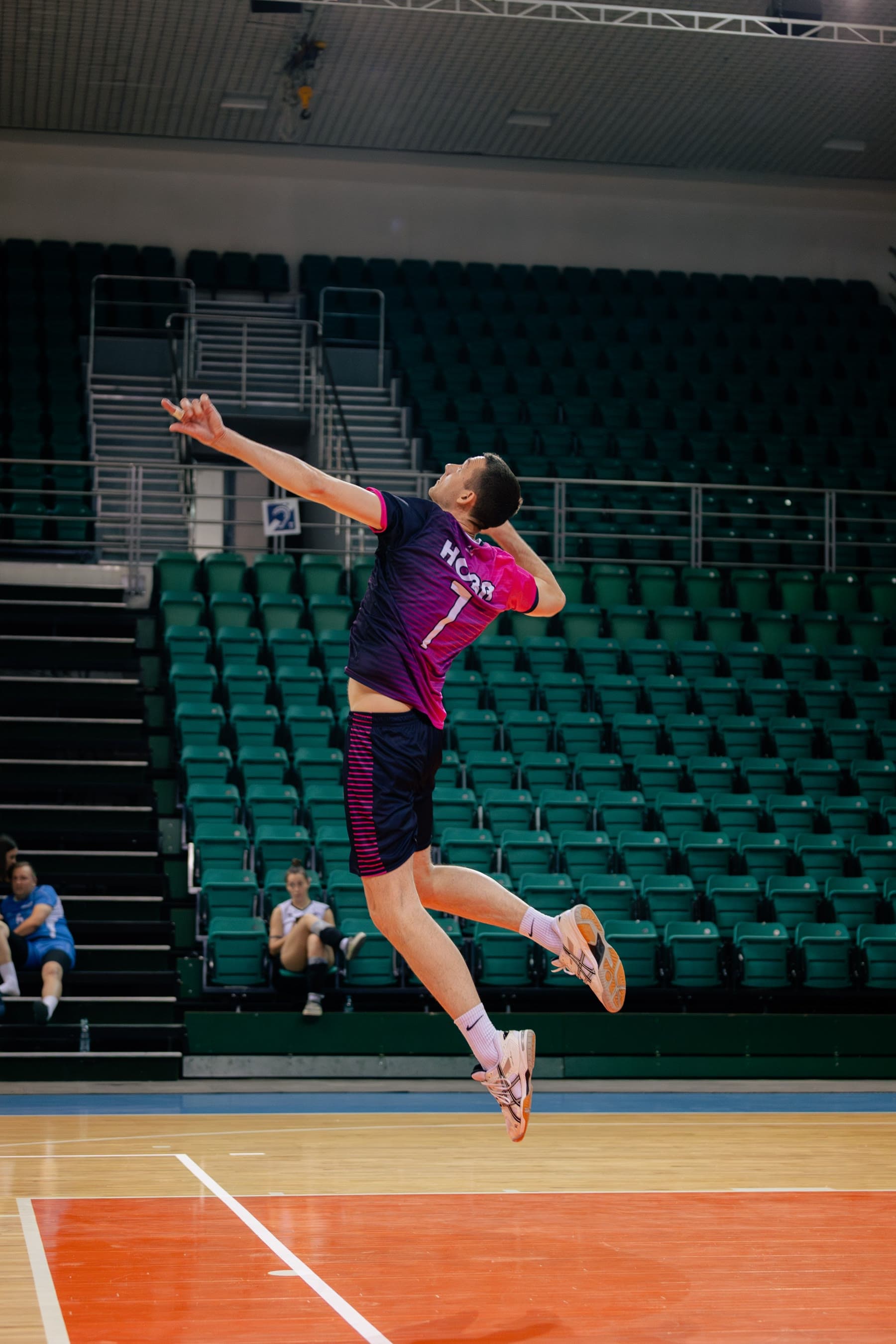 Volleyball player mid-air during a jump serve